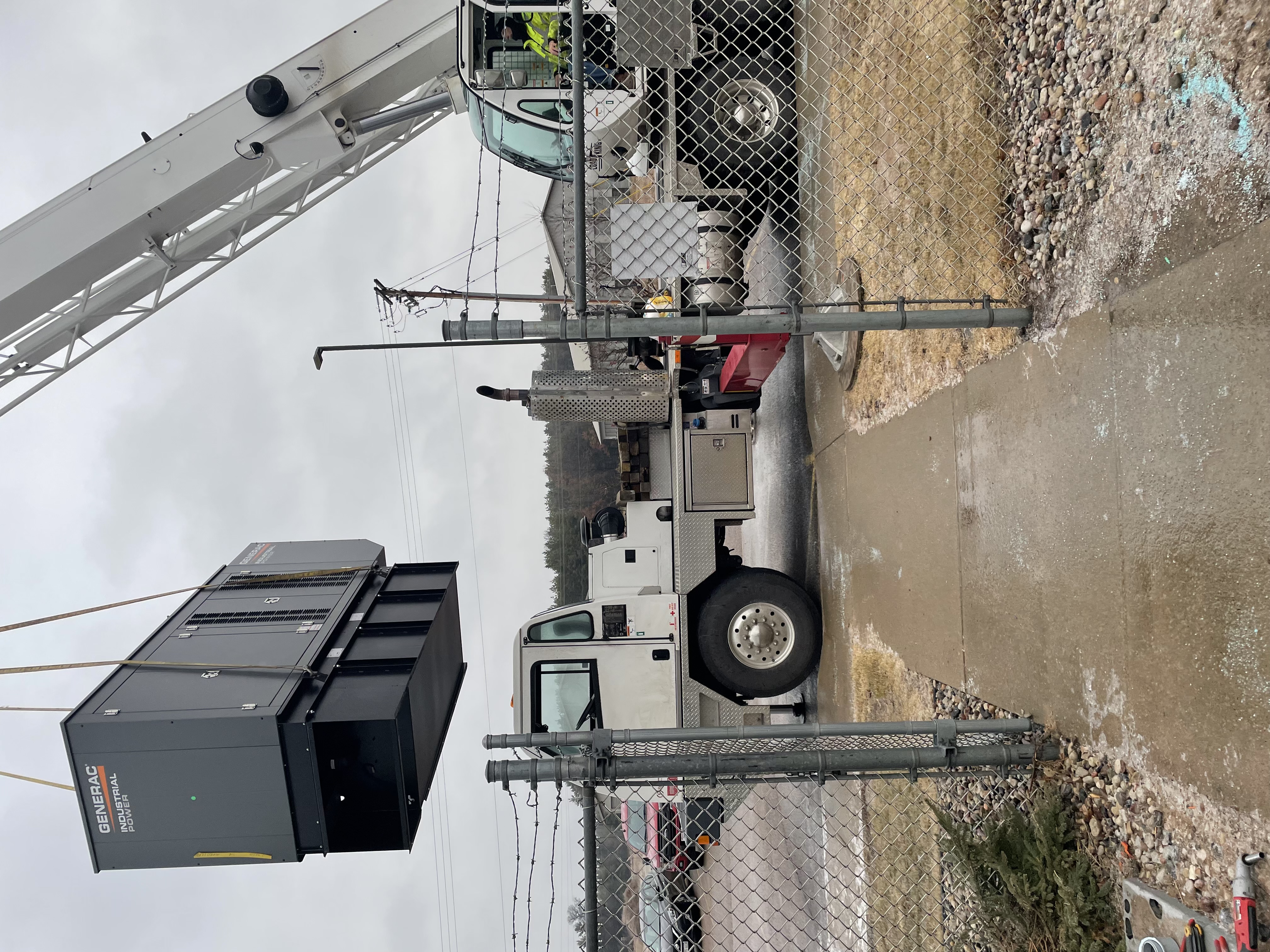 Large Generac Industrial Power commercial generator being set with a crane