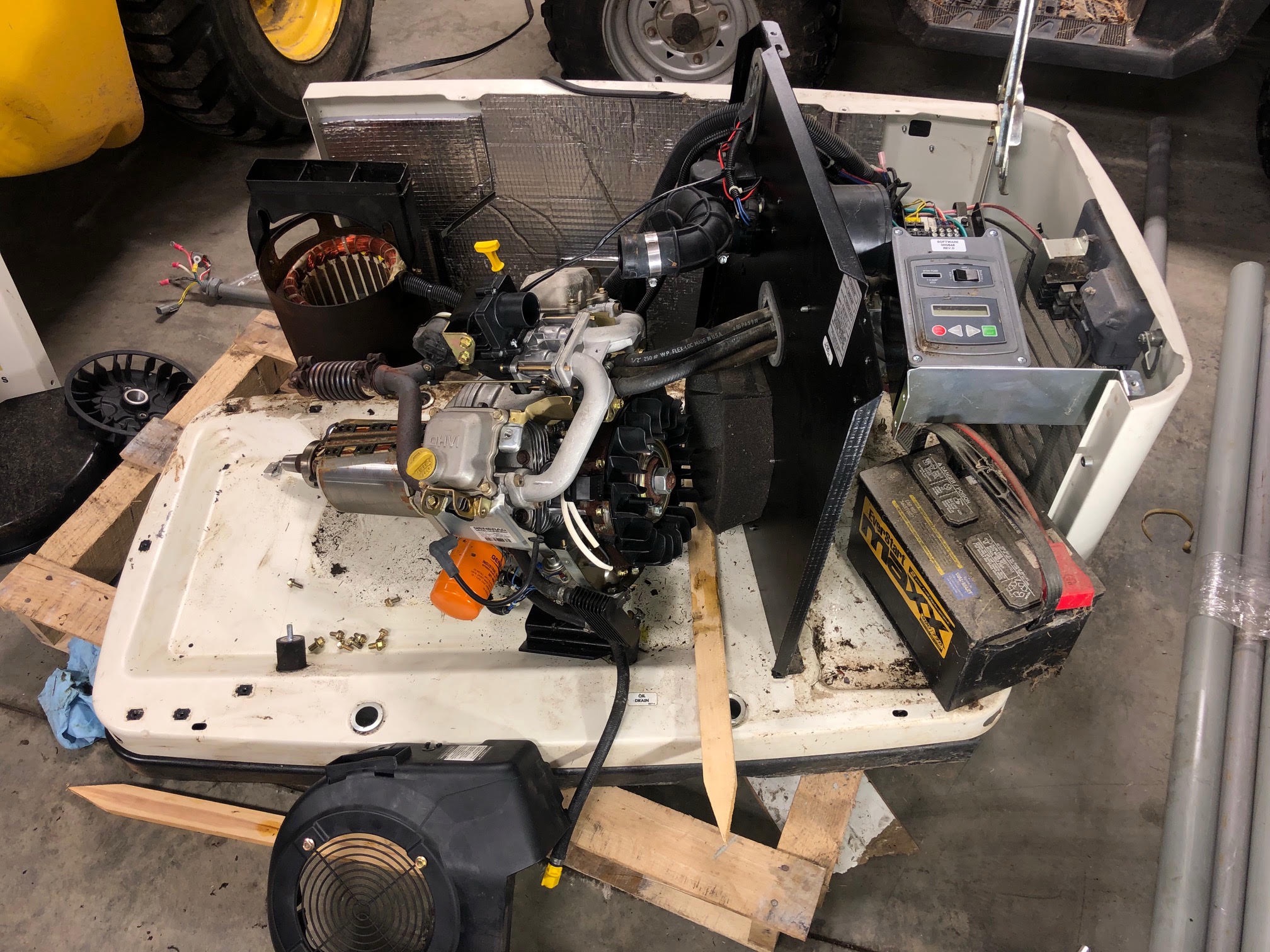 Generac generator engine and components laid out for a rebuild on a shop bench